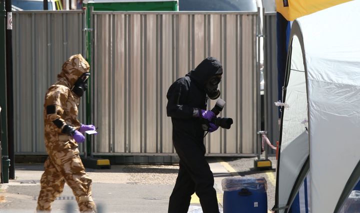 Investigators in chemical suit work behind screens erected in Rollestone Street, Salisbury, Wiltshire.