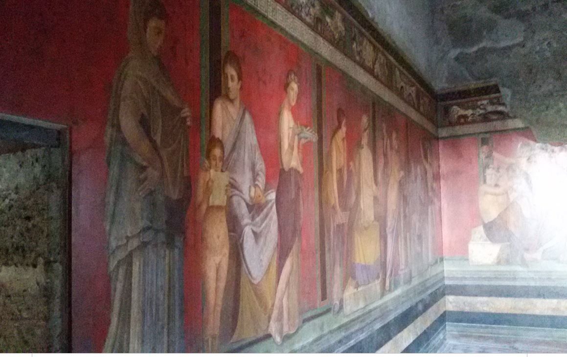 Η αριστερή πλευρά των τοιχογραφιών της αίθουσας των Μυστηρίων "The Initiation Chamber’’’ με το χαρακτηριστικό κόκκινο χρώμα ‘’Pompeii Red’’ και την μυστηριακή θεματολογία των μορφών και των απεικονίσεων