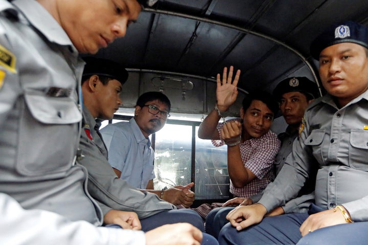 Detained Reuters journalist Wa Lone and Kyaw Soe Oo sit beside police officers as they leave Insein court in Yangon, Myanmar, on Monday.