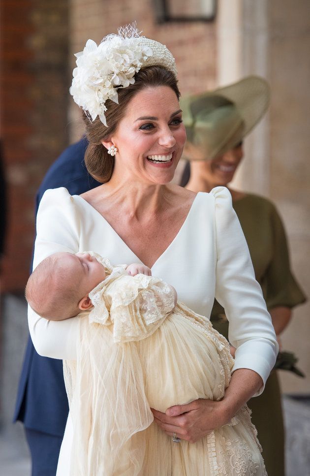 The Duchess of Cambridge carries Prince Louis. 