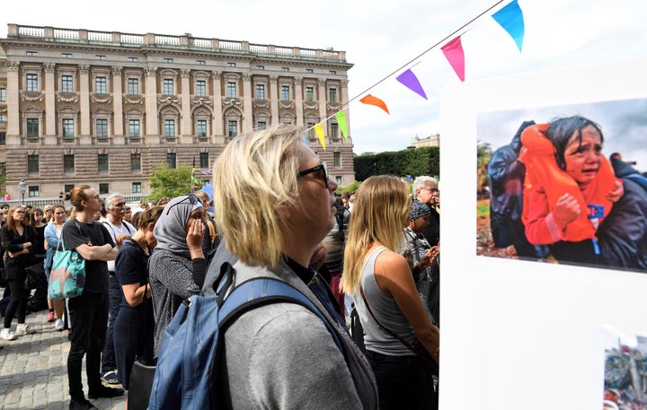 Protesters stand outside Sweden's parliament in Stockholm on June 21, 2016, after lawmakers passed legislation tightening asylum and family reunification laws.