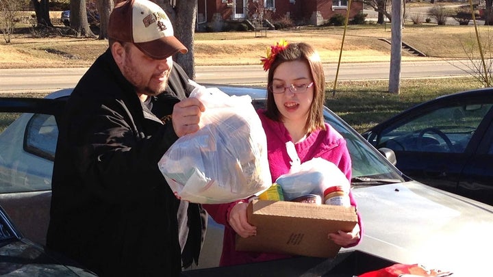 A man and a woman carry groceries from a food pantry in Jefferson City, Missouri.