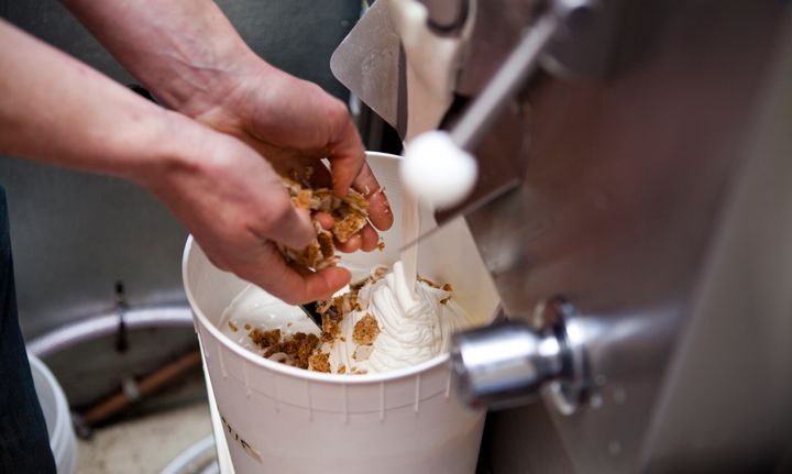 Mix-ins are hand-folded into the ice cream at Salt & Straw as it pours out of a batch freezer.
