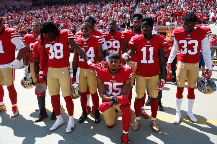 Eric Reid of the San Francisco 49ers leads the team in a "call to attention" during the playing of the national anthem before a game in September 2017. The NFL Players Association is challenging a new NFL policy that requires players on the field to stand during the anthem.