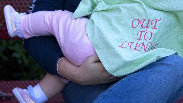 <p>A woman feeds her daughter outside of a Target in Texas.</p>