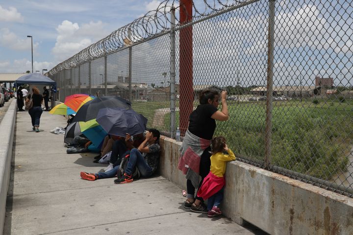 A Honduran mother and her 3-year-old daughter wait with fellow asylum-seekers on the Mexican side of the Brownsville-Matamoros International Bridge after being denied entry into the U.S.