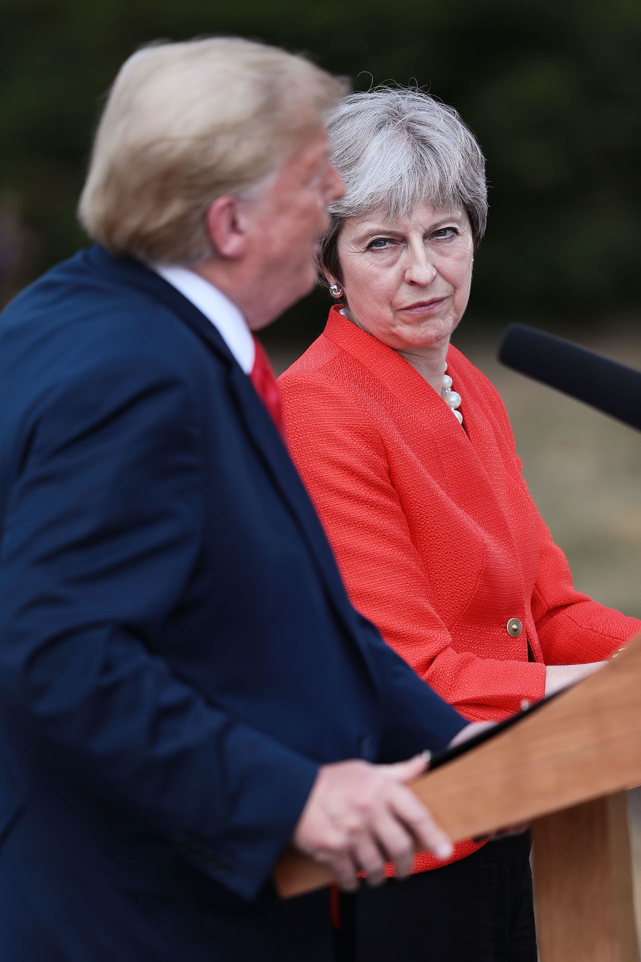 May listens as Trump addresses the press. 