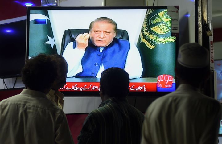 Pakistani men watch a televised addresses to the nation by Prime Minister Nawaz Sharif who has returned to Pakistan to face a 10-year prison sentence on corruption charges