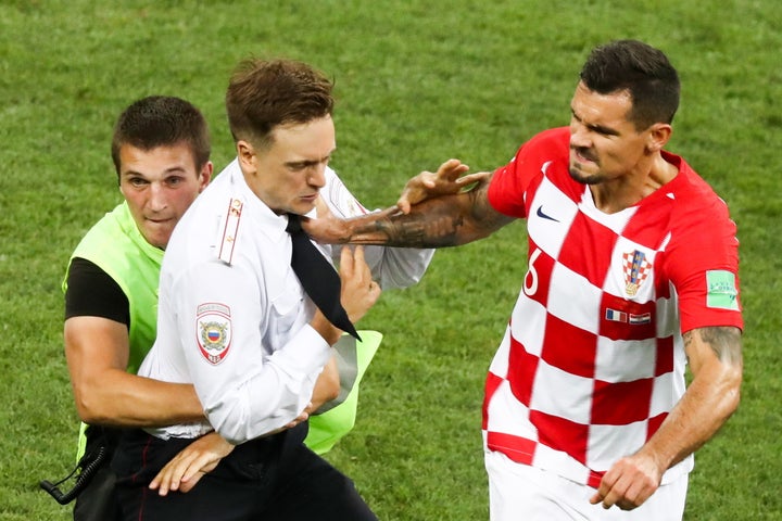 Croatia's Dejan Lovren shoves a man who invaded the field during the World Cup final's second half.