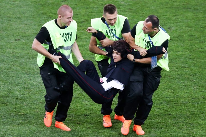 Security guards detain a field invader during the 2018 FIFA World Cup final match between France and Croatia at Luzhniki Stadium.