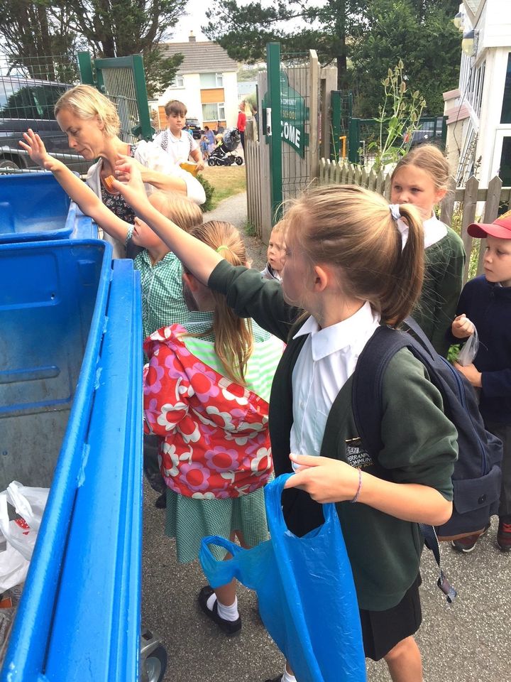 Primary school children dispose of what they've collected in their early morning litter pick.