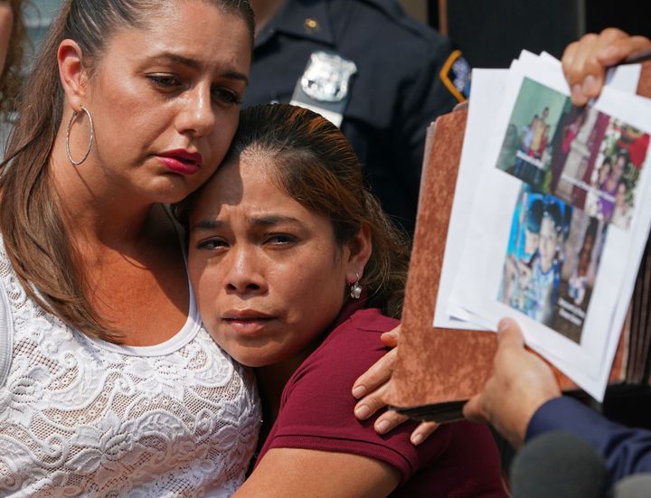 Yeni Marciela Gonzalez Garcia of Guatemala, center, who has been reunited with her three children at the Cayuga House in Harlem, looks at photos of other families during a news conference,