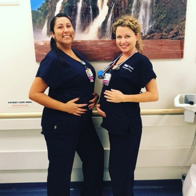 A pregnant Sarah poses with a co-worker.