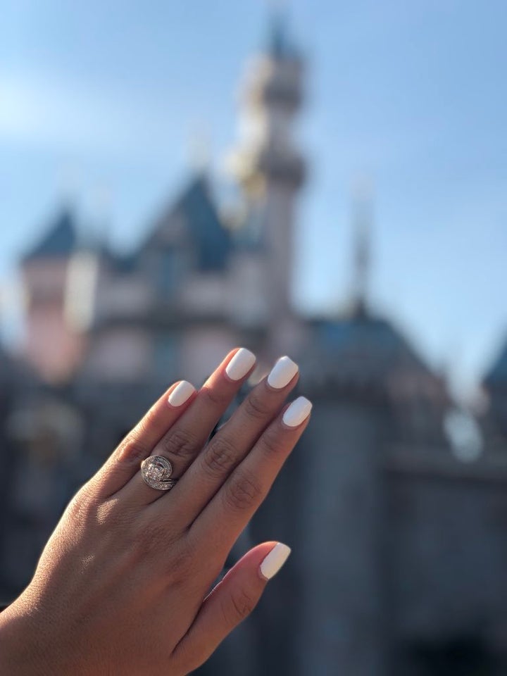 A photo of the engagement ring in front of Sleeping Beauty Castle at Disneyland.