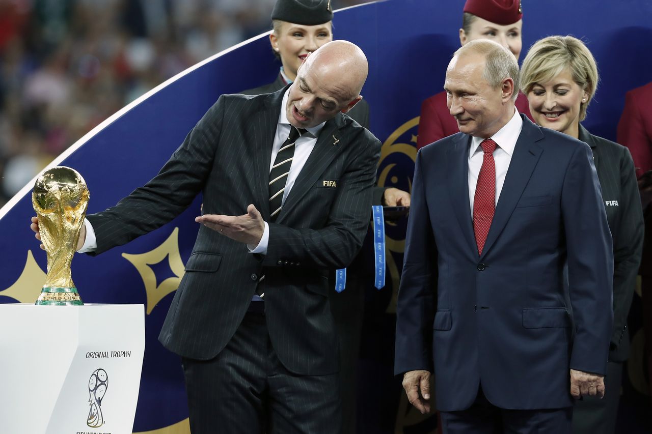 FIFA President Gianni Infantino, left, shows the World Cup trophy to Russian President Vladimir Putin after the final match in Moscow on July 15. Both entered this World Cup with a single goal: to bolster their legitimacy.
