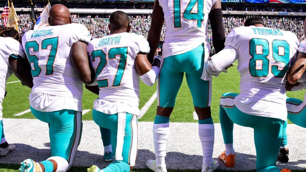 EAST RUTHERFORD, NJ - SEPTEMBER 24:  Laremy Tunsil #67, Maurice Smith #27 and Julius Thomas #89 kneel with Jarvis Landry #14 of the Miami Dolphins during the National Anthem prior to an NFL game against the New York Jets at MetLife Stadium on September 24, 2017 in East Rutherford, New Jersey.  (Photo by Steven Ryan/Getty Images)