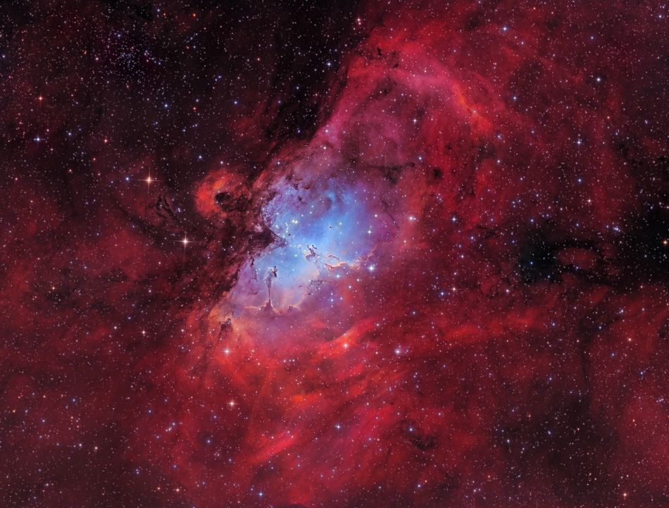 The Eagle Nebula also known as Messier 16 is a young open cluster of stars surrounded by hot hydrogen gas in the constellation Serpens and lies at a distance of 7000 light years from Earth Taken at the Baerenstein Observatory in Germany the photo is a RGB-Ha-OIII image and shows off the radiant red and blue colours of the nebula In the centre you can spot the famous Pillars of Creation Baerenstein Germany 9 August 2017