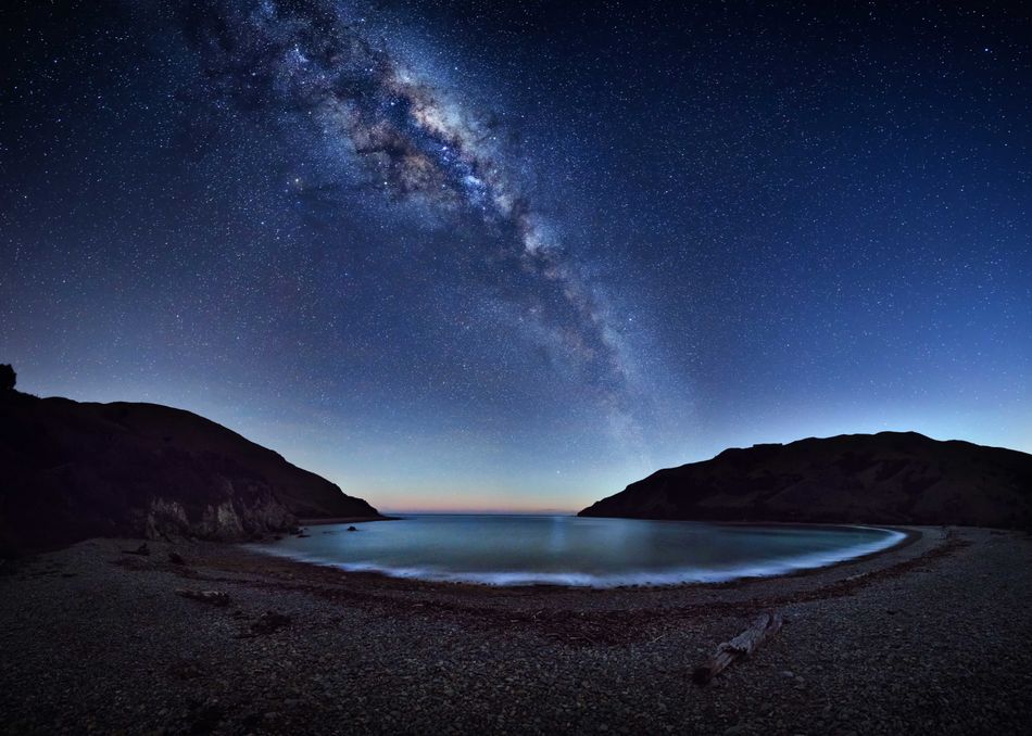 The magnificent Milky Way stretches across the night sky reflecting on the Cable Bay near Nelson New Zealand The photographer had to take the picture before the light washed out the sky 42 individual images were stitched in to a large multi row panorama to create this image image Nelson New Zealand 12 August 2017