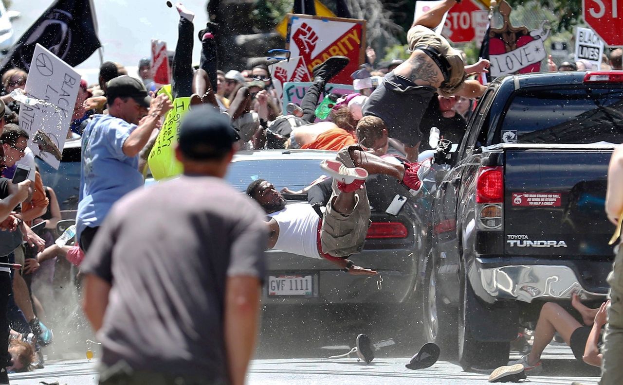People fly into the air as a vehicle drives into a group of protesters in Charlottesville on Aug. 12, 2017.