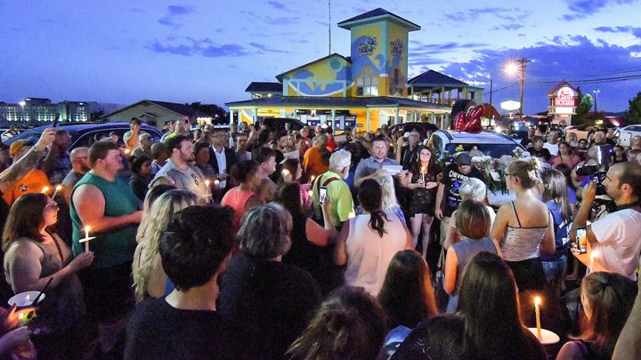 Mourners gather in the parking lot of the Ride the Ducks offices in Branson, Mo., during a candle light vigil on Friday