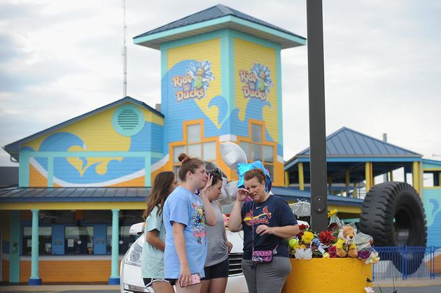 A group of mourners pause for a moment of prayer at Ride The Ducks Tours on Friday.