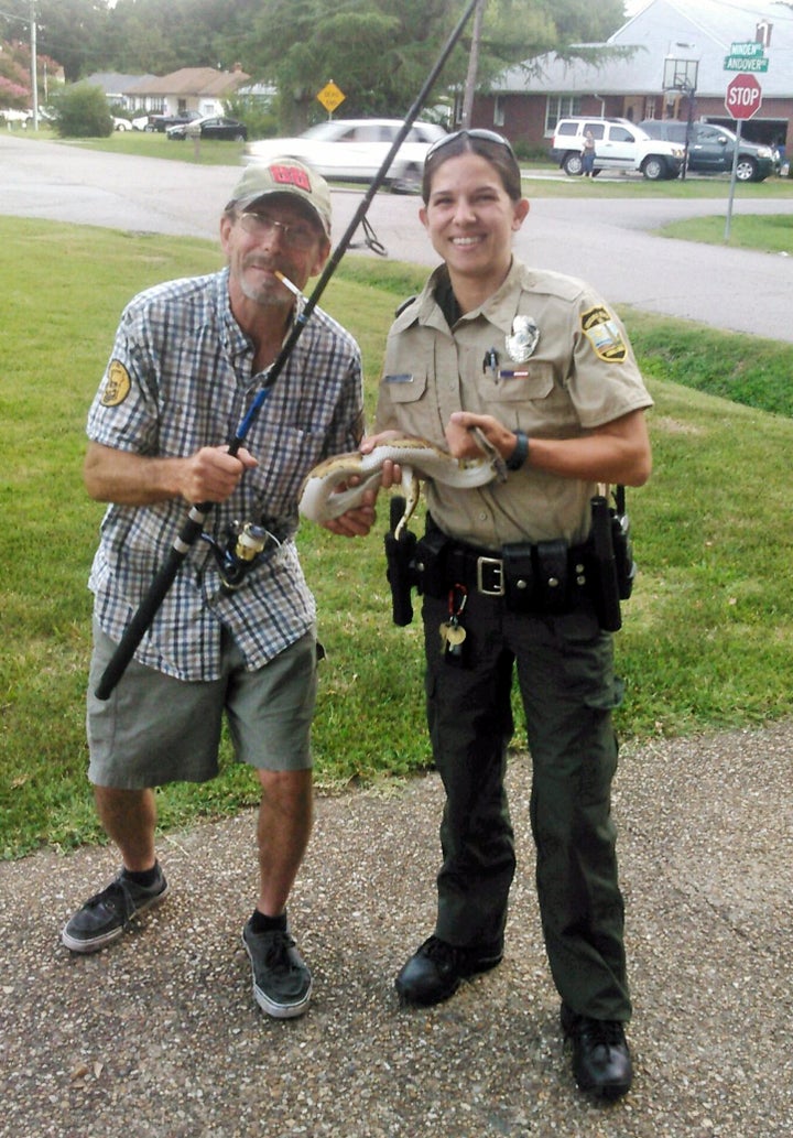 Kenny Spruill and an unidentified animal control officer pose with the female ball python. The reptile, a lost pet, was later reunited with her owner.