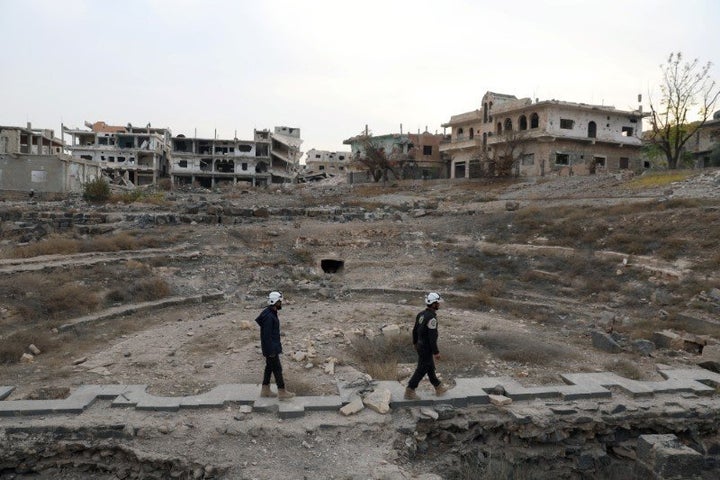 Members of the Civil Defence, also known as the 'White Helmets', are seen inspecting the damage at a Roman ruin site in Daraa, Syria December 23, 2017.