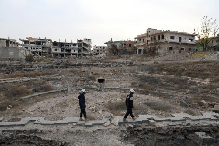 Members of the Civil Defence, also known as the 'White Helmets', are seen inspecting the damage at a Roman ruin site in Daraa, Syria December 23, 2017. 