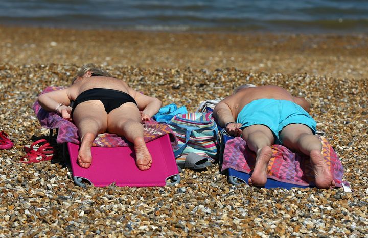 A couple enjoy the warm weather on the beach in Whitstable, Kent, as the hot weather continues.