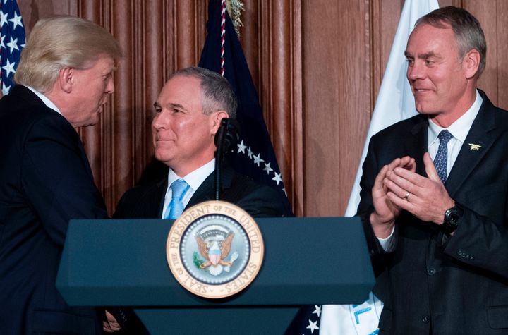 President Donald Trump shakes hands with Scott Pruitt before signing an executive order at the EPA's Washington, D.C., headquarters in March 2017. Zinke is at right.