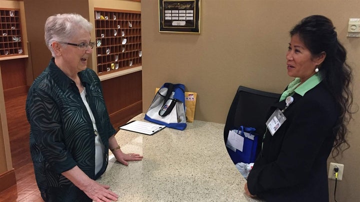 Kathleen Henry talks with a staffer at Greenspring retirement community in Springfield, Virginia. Henry leads voter registration at the precinct. 