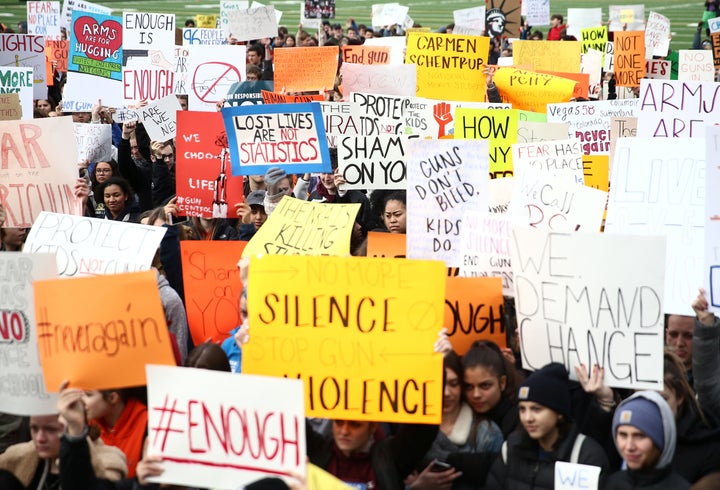 High school students in Seattle hold up signs on their football field during the National School Walkout to protest gun violence on March 14, 2018. 