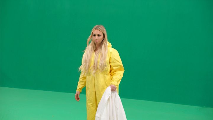 "Bachelor" star Corinne Olympios poses as an aid worker who helped combat an ebola outbreak in Sierra Leone. She didn't perform such service, and the scene for the second episode of "Who Is America?" was filmed in front of a green screen.