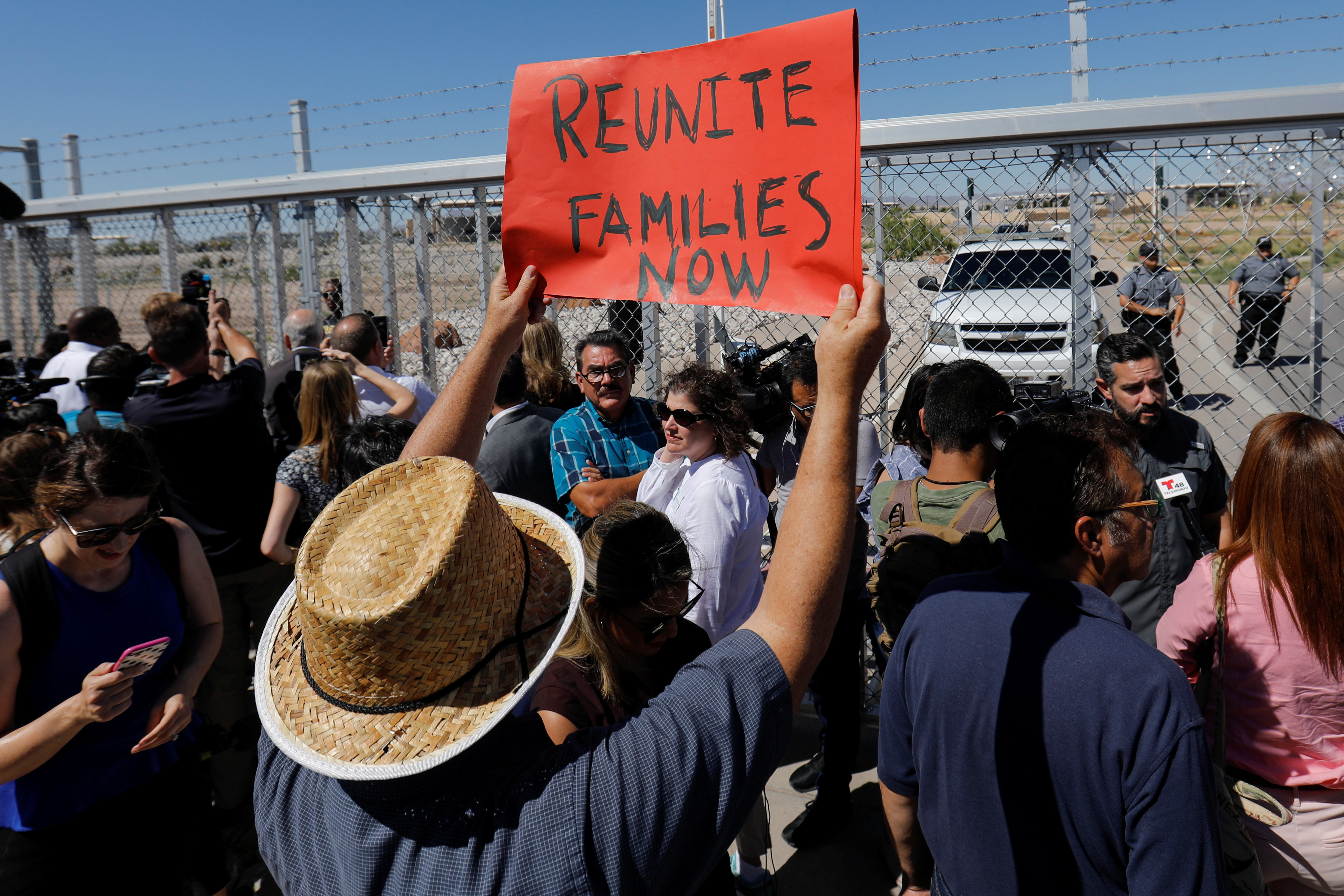   A protester wavers a sign as mayors of American cities are prevented from entering the children's tent in Tornillo, Texas on June 21. 