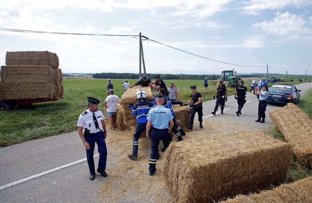  Police officers remove hay bales off the road after a protest. 