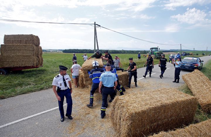  Police officers remove hay bales off the road after a protest. 
