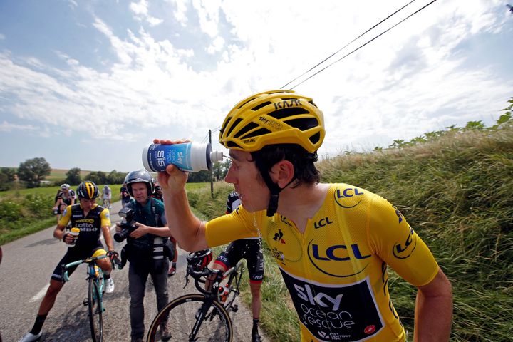 Team Sky rider Geraint Thomas of Britain, wearing the overall leader's yellow jersey, cleans his eyes.