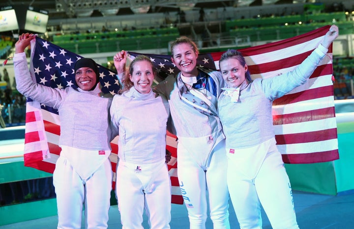 America's Ibtihaj Muhammad, Mariel Zagunis, Monica Aksamit, and Dagmara Wozniak (left to right) pose after their victory over Italy in the women's saber team bronze medal match at the 2016 Summer Olympic Games.