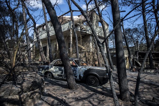 A photo taken on July 25, 2018 shows cars burnt following a wildfire in the village of Mati, near Athens.