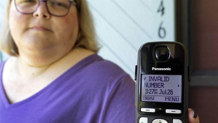 A Florida woman shows a robocall she received on her home phone in Orlando. Despite consumer awareness, state and federal eff