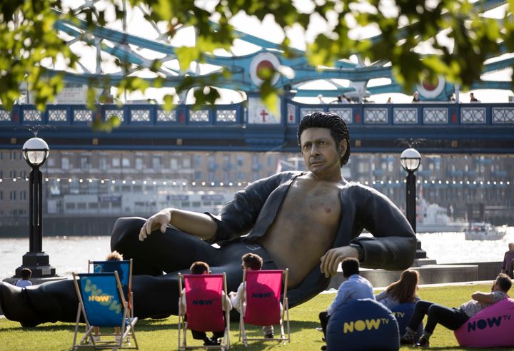 People in lawn chairs marvel at the sexy, lounging statue of actor Jeff Goldblum, which recreates his memorable bare chested scene in "Jurassic Park."