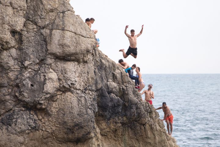 People jump in the sea at Durdle Door in Dorset on Thursday, which became the hottest day of the year so far.