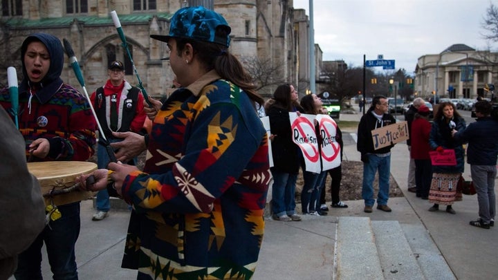 A group of men sing and drum on the steps of Kalamazoo City Hall in March, before the city commission voted to remove the Fou