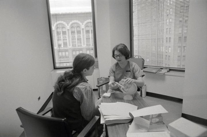 In a New York City abortion clinic in 1971, a patient is shown a model of the female reproductive system by a clinic member. 