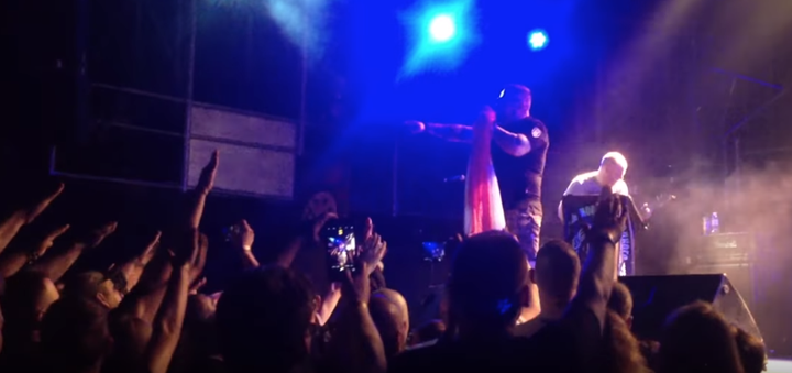 A YouTube video screenshot of one of Bilodub's concerts. The crowd repeatedly throws up Nazi salutes as Bilodub sings on stage.