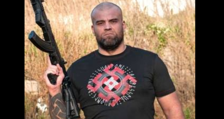 A post from Sva Stone's Facebook page shows a man modeling one of its Nazi-inspired T-shirts while holding a gun.