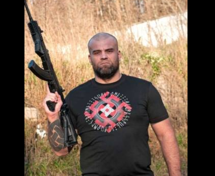 A post from Sva Stone's Facebook page shows a man modeling one of its Nazi-inspired T-shirts while holding a gun.