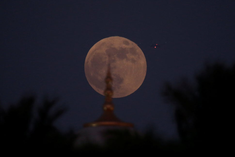 The moon rises behind the Sheikh Zayed Grand Mosque in Abu Dhabi.