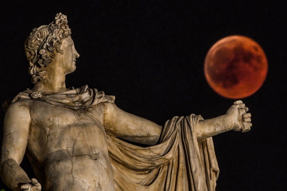 Rising beside a statue of the ancient Greek god Apollo in central Athens, Greece.