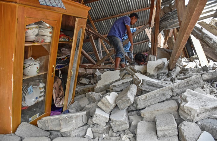 A villager walks through the ruins of a collapsed house following the earthquake at the Sembalun Selong village in Lombok Timur, Indonesia, July 29, 2018.